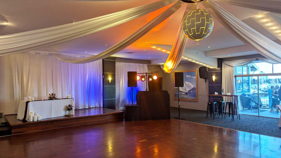 Wedding DJ setup with Pioneer decks, JBL speakers and lighting at a Mounts Bay Sailing Club Wedding Reception dancefloor lighting setup Mounts Bay Sailing Club